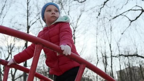 Slow motion futage of Funny little girl wspina się po metalowych schodach na placu zabaw w parku. — Wideo stockowe