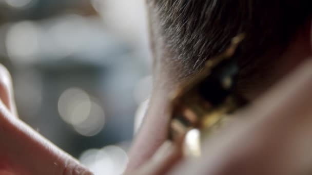 Vue rapprochée du coiffeur coupe les cheveux des jeunes hommes à l'aide d'une tondeuse à cheveux. Plan au ralenti — Video