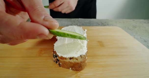 Uno chef in cucina spalma formaggio morbido sul pane tostato. Chiudere al rallentatore. Da vicino. — Video Stock