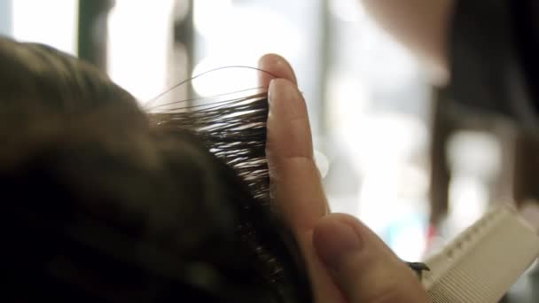 Primer plano de peluquero corta el pelo de los hombres jóvenes con tijeras. Movimiento lento — Vídeo de stock