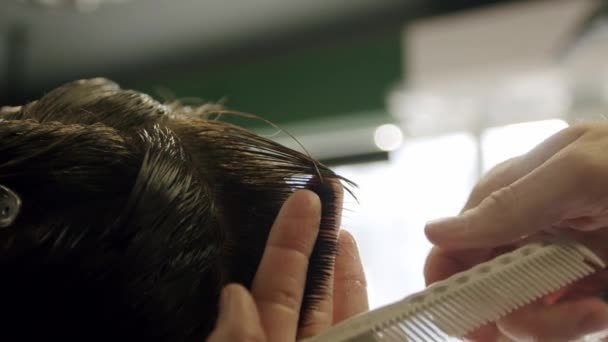 Primer plano de peluquero corta el pelo de los hombres jóvenes con tijeras. Movimiento lento — Vídeos de Stock