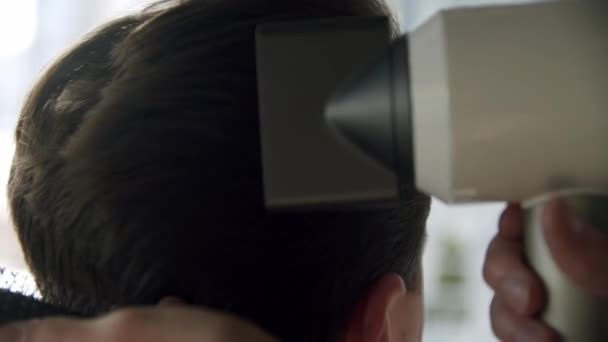 Close-up zicht van professionele kapper creëert een stijlvolle mannen kapsel met een haardroger en een borstel in zijn handen. Langzame beweging — Stockvideo