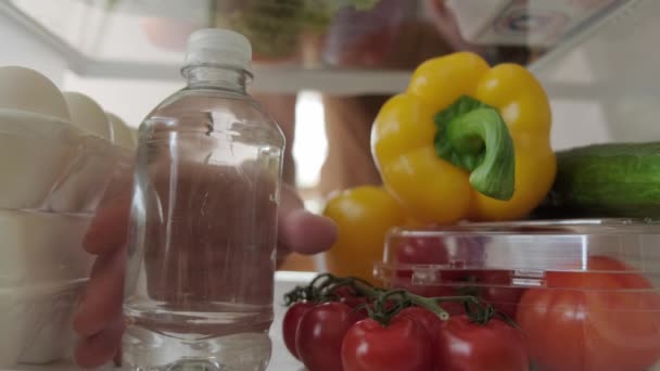 Вид всередину холодильника, рука бере їжу з холодильника — стокове відео