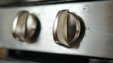 El mutfaktaki gaz sobasını yakıyor.