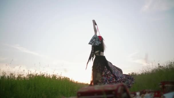 Kvinde i etnisk tøj danser ved solnedgang. Langsom bevægelse – Stock-video