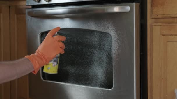 Man in gele rubberen handschoenen schoonmaken elektrische oven handvat. Sluiten. — Stockvideo