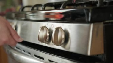 Mutfaktaki gaz sobasının el görüntüsünü kapat.. 