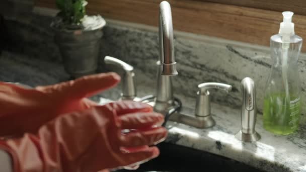 手戴橙色手套，在厨房洗碗。关闭查看版本2 — 图库视频影像