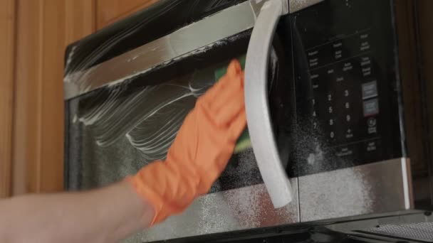 Man in gele rubberen handschoenen schoonmaken oven handvat. Sluit maar af. Langzame beweging — Stockvideo