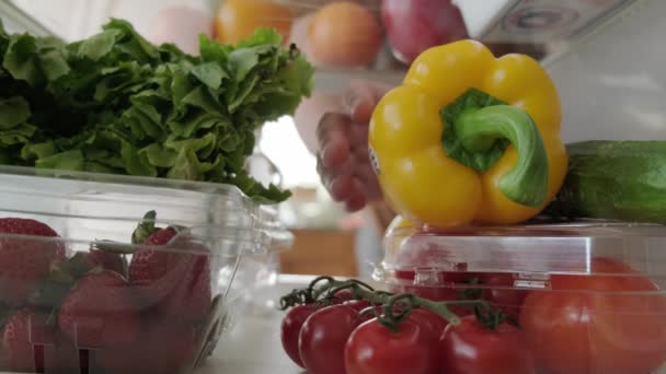 Kilátás a hűtőszekrénybe, kézzel veszi ki az ételt a hűtőszekrényből. Közelkép. — Stock videók