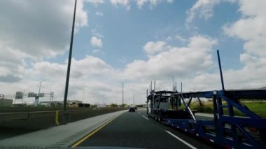 POV view from the cab of a car driving on a highway near the truck. slow motion