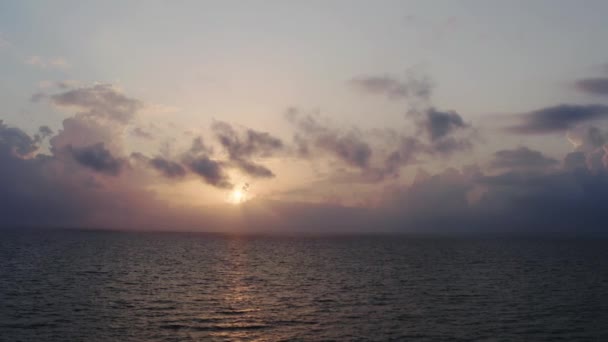 Färgglada ljusa moln under solnedgången över havet eller havet, flygfoto. — Stockvideo