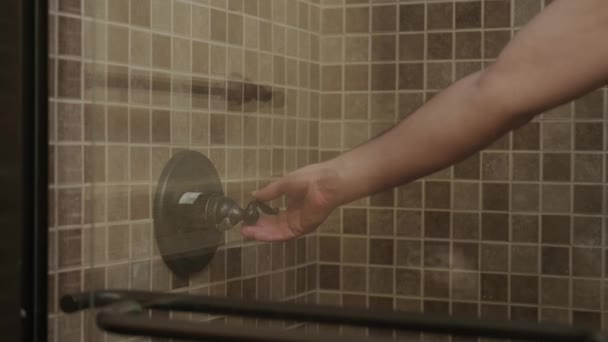 Blured Man hand includes shower handle behind blurry glass — Stock Video