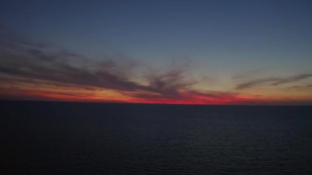 Nubes brillantes coloridas durante el atardecer sobre el mar o el océano, fuga aérea de drones. — Vídeos de Stock