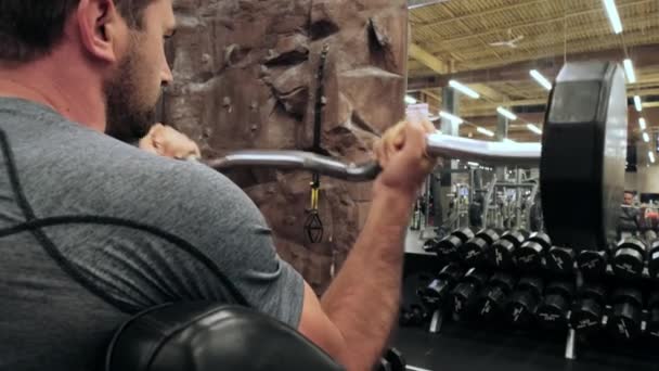 Slow motion shot. Modern gym, a guy sitting down on the training apparatus and training. Close up — Stock Video