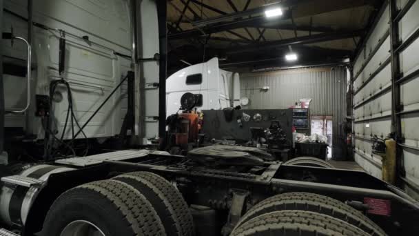 Lastbilsreparationsverkstaden, kameran rör sig från den demonterade lastbilen till mitten av verkstaden. Flytta kameran — Stockvideo