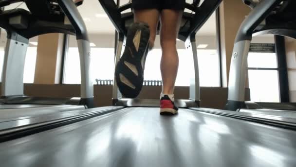 Close up outage of Man walking on running track, warming up on gym treadmill. Slow motion — Stock Video