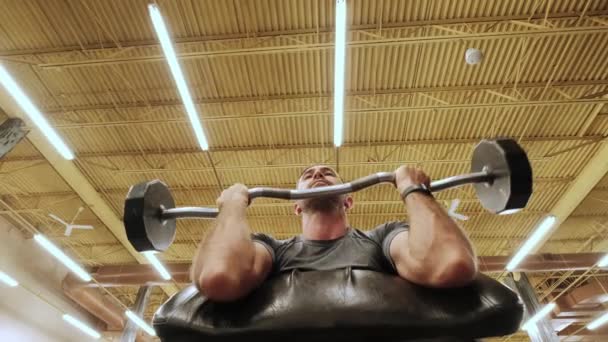 Slow motion shot. Modern gym, a guy sitting down on the training apparatus and training. Midel shot — Stock Video