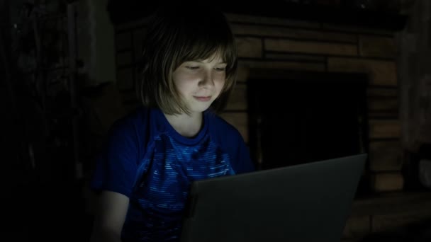 Närbild futage av liten pojke på Internet. sitter på golvet med en bärbar dator på natten — Stockvideo