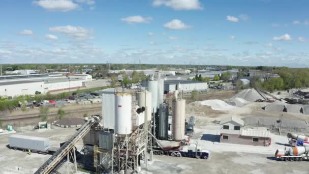 Letecký výhled. Cement továrny budovy a velké nádrže s materiály proti průmyslovému městu na kopcích pěšky na slunný den. — Stock video