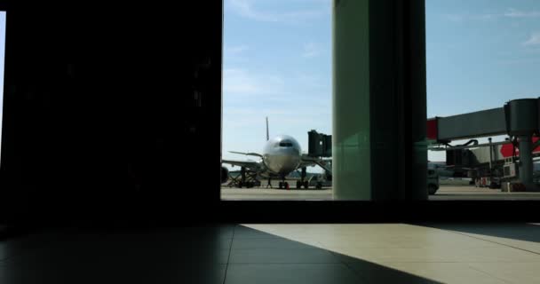 Silhouette d'une femme marchant de l'aéroport avec ses bagages.. éruption de soleil en arrière-plan. Concept voyage ou voyage. Mouvement lent — Video