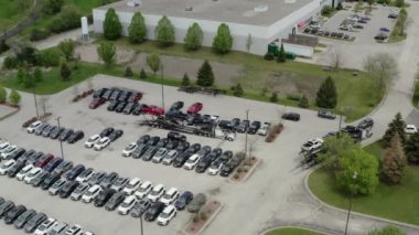 Taşıyıcı karavan aracının hava aracı görüntüsü arabaları karavana yüklüyor, satıcının otoparkına.