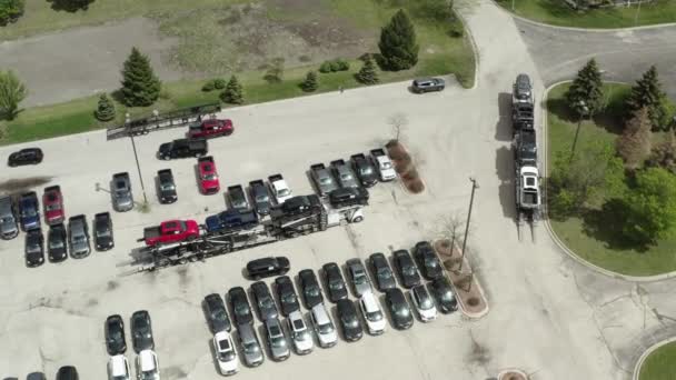 Luchtfoto drone van de auto vervoerder aanhanger vervoerder laadt auto 's op de aanhangwagen, op het parkeren van de dealer partij — Stockvideo
