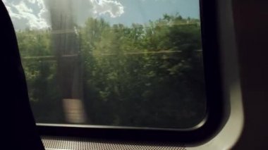 Gündüz vakti hareket halindeki bir trenin penceresinin kenarı. Gün içinde yavaş çekim