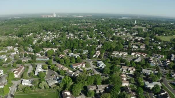 Ett luftdrönarskott. Utsikt över amerikansk förort på sommaren. Etablerar bilder av grannskapet. Fastighetsutsikt över bostadshus. Brett skott — Stockvideo