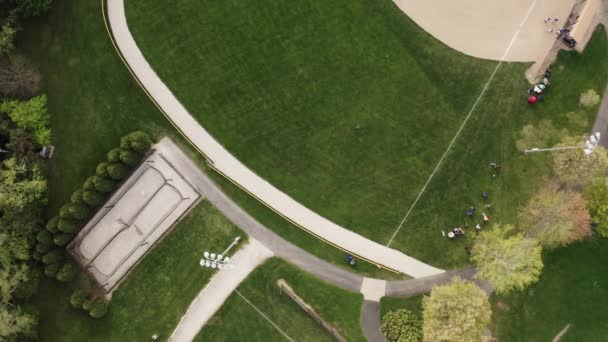 阳光灿烂的日子,空中飞行员看到孩子们在公园打棒球场.顶部视图 — 图库视频影像