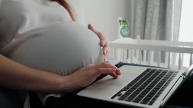 Hamile Kadın 'ın Evdeki Bir Koltuğa Uzaktan Dinlenen ve Bilgisayarla Uzaktan Çalışan Online Teknoloji Kullanarak Geleceğini Kapat.