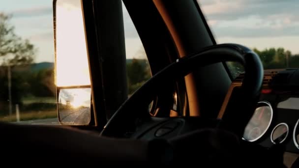 Zbliżenie Kierowca ciężarówki jedzie do miejsca przeznaczenia ładunku na drodze w dzień w promieniach słonecznych. Zwolniony ruch — Wideo stockowe