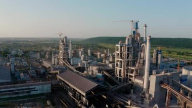 Hava aracı atışı. Gün batımında endüstriyel üretim alanında yüksek fabrika yapısına sahip çimento fabrikası.