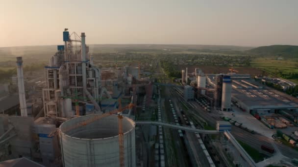 Cement plant with high factory structure at industrial production area at sunset. Aerial drone view — Stock Video