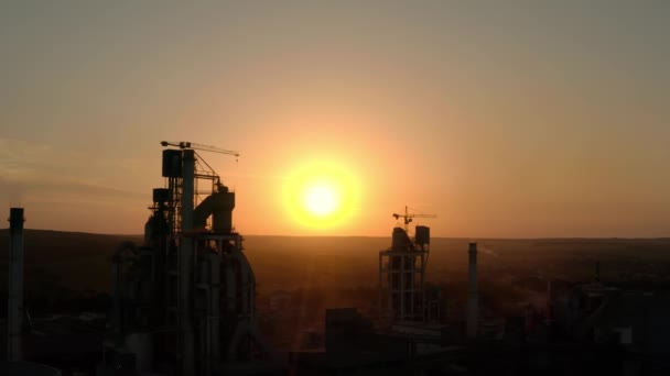 Vista para cima da fábrica de cimento silhueta com alta estrutura de fábrica na área de produção industrial ao pôr do sol. Vista aérea de drones — Vídeo de Stock