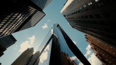 Sakin bir günde bulutlu gökyüzünün altında, huzurlu bir şehirde, birkaç gökdelenin yanından geçidin alt manzarası. Kamerayı döndür