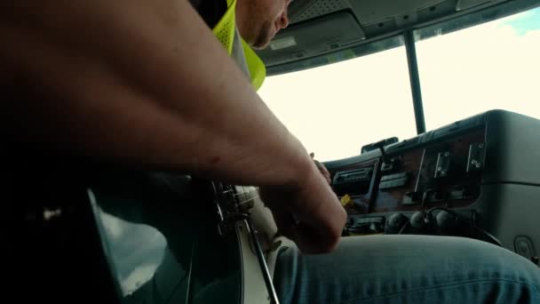 Ferme là. Le chauffeur du camion est assis dans le taxi et joue de la guitare — Video