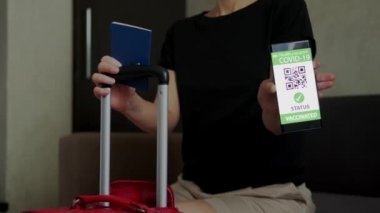 Cep telefonundaki aşı pasaportu bavulda seyahat olanağı sağlıyor. Kapat.