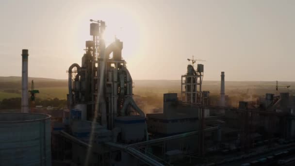 Aerial drone close up shot of silhouette cement plant with high factory structure at industrial production área at sunset. — Vídeo de stock