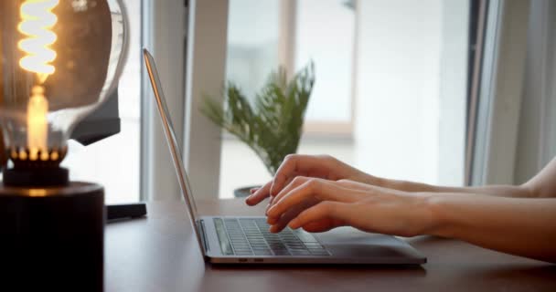 Weibliche Hände, die auf der Laptop-Notebook-Tastatur tippen, sitzen am Schreibtisch zu Hause und arbeiten online, Seitenansicht aus der Nähe — Stockvideo