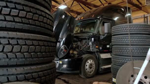 Reparatiewerkplaats voor vrachtwagens. Camera beweegt naar de baan waarin hij in de werkplaats staat. Breed beeld — Stockvideo