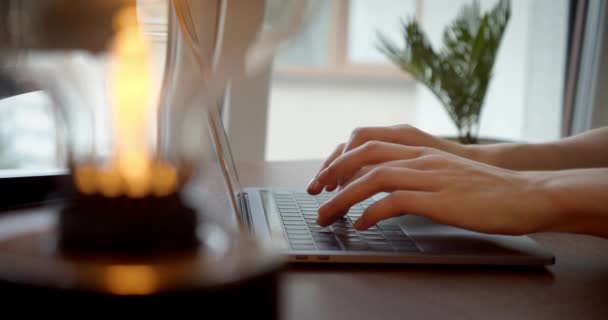 Naisen kädet kirjoittaminen kannettavan tietokoneen kannettavan näppäimistön istua kotitoimiston työpöytä verkossa, lähikuva puoli laukaus — kuvapankkivideo