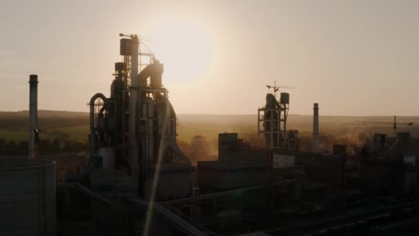 Drohnenschuss aus der Luft. Silhouetten-Zementwerk mit hoher Fabrikstruktur im Industriegebiet bei Sonnenuntergang. — Stockvideo