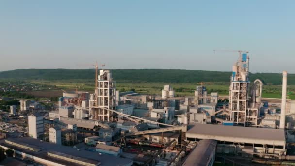 Fábrica de cimento com alta estrutura de fábrica na área de produção industrial ao pôr do sol. — Vídeo de Stock