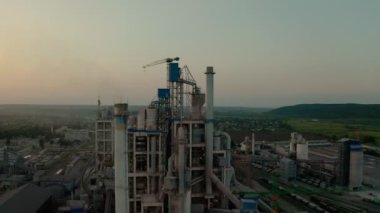 Gün batımında endüstriyel üretim alanında yüksek fabrika yapısına sahip çimento fabrikası. İnsansız hava aracı geleceği