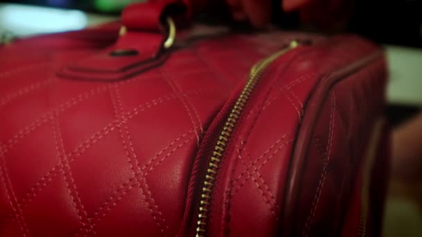 Shot of zipping metallic zipper on red leather travelling bag. Close up — 图库视频影像