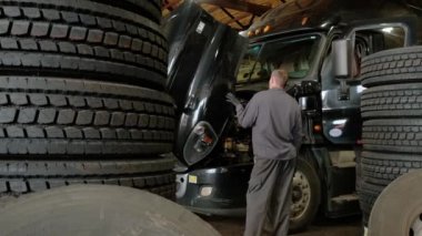 Kamyon tamirhanesi. Kamera atölyede durduğu yere doğru hareket ediyor. Geniş kamera görüntüsü