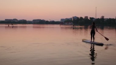 Sunset, Woman Silhouette on lake Stand Up Paddle Board SUP, Wide view futage