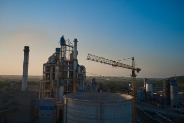 Gün batımında endüstriyel üretim alanında yüksek fabrika yapısına sahip çimento fabrikası. Drone fotoğraf sürümü 2