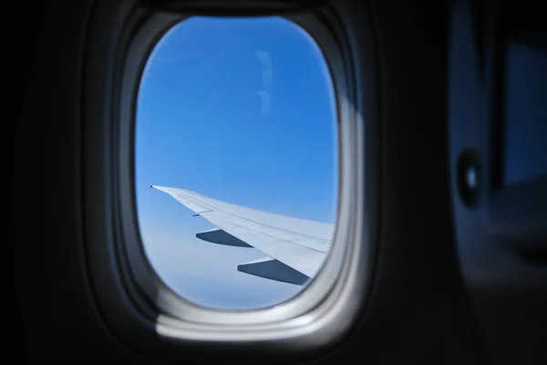 View through the window of the plane on Airplane wing on the blue sky Version2 — Stock Photo, Image